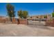 Property with wooden gate and fence surrounding a gravel yard with lush trees adding privacy at 9710 E Baywood Ave, Mesa, AZ 85208