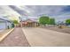 Inviting home exterior featuring a long driveway and professionally trimmed trees at 9710 N 55Th Ave, Glendale, AZ 85302