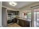 Traditional kitchen features stainless steel appliances, dark cabinetry, and a large sink under a picture window at 9710 N 55Th Ave, Glendale, AZ 85302