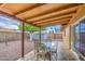 Covered patio with table and chairs in a fenced backyard with low-maintenance landscaping at 9710 N 55Th Ave, Glendale, AZ 85302