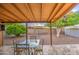 Covered patio featuring a tile floor, a glass top table with chairs and lush landscaping at 9710 N 55Th Ave, Glendale, AZ 85302