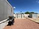 The backyard has two storage sheds, gravel, and a grill, all under a clear blue sky at 1002 W Kachina Trl, Phoenix, AZ 85041