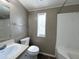 Bright bathroom featuring a shower-tub combo, sink, and toilet with a window at 1002 W Kachina Trl, Phoenix, AZ 85041