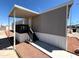 This well-maintained mobile home features an inviting front entrance with a covered porch and desert landscaping at 1002 W Kachina Trl, Phoenix, AZ 85041