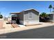 Beautiful mobile home with desert landscaping, a covered porch, and a paved driveway at 1002 W Kachina Trl, Phoenix, AZ 85041