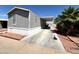 Charming mobile home featuring desert landscaping, a covered carport and a cozy front yard at 1002 W Kachina Trl, Phoenix, AZ 85041