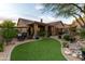 Lush backyard with artificial turf, covered patio, and mature desert landscaping at 10527 E Acacia Dr, Scottsdale, AZ 85255