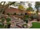 Beautiful backyard with a stone staircase leading to a sitting area and mature trees at 10527 E Acacia Dr, Scottsdale, AZ 85255