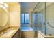 Bright bathroom with granite countertop, soaker tub behind glass partition, and window at 10527 E Acacia Dr, Scottsdale, AZ 85255