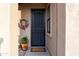 Charming front door with security screen and welcoming wreath and potted plant at 10527 E Acacia Dr, Scottsdale, AZ 85255