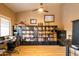 Home office with large shelving units, wooden floors, and a ceiling fan at 10527 E Acacia Dr, Scottsdale, AZ 85255