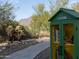 Community Little Free Library stocked with books, nestled along a desert walking path for neighborhood enjoyment at 10527 E Acacia Dr, Scottsdale, AZ 85255
