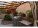 Built-in outdoor kitchen area with a grill, counter space and string lights overhead at 10527 E Acacia Dr, Scottsdale, AZ 85255