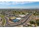 Wide aerial view of a residential area with community center featuring a pool, park, and sports courts at 10860 W Cheryl Dr, Sun City, AZ 85351