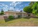 Cozy home featuring a screened-in porch, lush lawn, and mature landscaping in the backyard at 10860 W Cheryl Dr, Sun City, AZ 85351