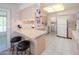 Bright kitchen with breakfast bar, tiled floors and sliding glass door to enclosed patio at 10860 W Cheryl Dr, Sun City, AZ 85351