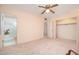 Carpeted main bedroom with ensuite bathroom and closet at 10860 W Cheryl Dr, Sun City, AZ 85351