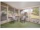 Enclosed patio with screened windows and two chairs looking out to the backyard at 10860 W Cheryl Dr, Sun City, AZ 85351