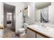 Bright bathroom with a white vanity, an oval sink, and a decorative cabinet and butterfly wall decor at 1116 S 53Rd St, Mesa, AZ 85206