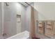 Bathroom features a combination tub and shower with neutral, tiled walls with a toiletry niche at 11500 E Cochise Dr # 1015, Scottsdale, AZ 85259
