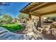 This is an outdoor kitchen featuring stone accents, a grill, a table, and seating, perfect for enjoying outdoor meals at 11500 E Cochise Dr # 1015, Scottsdale, AZ 85259