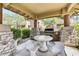 A cozy outdoor kitchen space has a built-in grill, stone accents, and a table with built-in seating for outdoor dining at 11500 E Cochise Dr # 1015, Scottsdale, AZ 85259