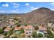Expansive aerial view of hillside homes, featuring pools and mountain views under a bright blue, cloudy sky at 1221 E Claire Dr, Phoenix, AZ 85022