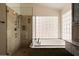 Bathroom features a bathtub with shower, neutral tiling, and granite countertop vanity at 1221 E Claire Dr, Phoenix, AZ 85022