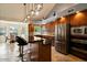 Spacious kitchen featuring stone countertops, an island with seating, and modern stainless-steel appliances at 1221 E Claire Dr, Phoenix, AZ 85022