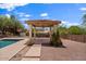 Inviting pool area with a covered patio and meticulously landscaped grounds, a perfect outdoor retreat at 1221 E Claire Dr, Phoenix, AZ 85022