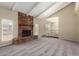 Spacious living room with a brick fireplace, large windows, and neutral carpeting at 1225 E Jacob Ln, Phoenix, AZ 85020