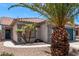 Charming single-story home with a tile roof, desert landscaping, and mature palm trees in the front yard at 12913 W Columbine Dr, El Mirage, AZ 85335