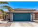 Attached garage with concrete driveway, desert landscaping and a well-maintained colorful blue door at 12913 W Columbine Dr, El Mirage, AZ 85335