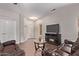 Inviting living room with tile flooring, neutral walls, modern TV stand with fireplace, and comfortable leather seating at 12913 W Columbine Dr, El Mirage, AZ 85335
