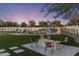 Inviting backyard featuring a pool with a slide, lush lawn, and a cozy fire pit area perfect for outdoor relaxation at 13365 N 74Th St, Scottsdale, AZ 85260
