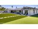 Beautiful backyard with artificial turf, outdoor kitchen, covered patio, and seating area at 13365 N 74Th St, Scottsdale, AZ 85260