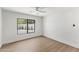 Clean bedroom features wood-look flooring, a modern ceiling fan, and a large window overlooking the yard at 13365 N 74Th St, Scottsdale, AZ 85260