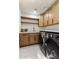 Well-lit laundry room features modern appliances, stylish cabinets, and light patterned tile flooring at 13365 N 74Th St, Scottsdale, AZ 85260