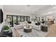 Bright living room and kitchen area with a large sectional couch, tiled floors, and backyard views at 13365 N 74Th St, Scottsdale, AZ 85260
