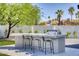 Built-in outdoor kitchen features bar seating and stainless steel grill perfect for entertaining at 13365 N 74Th St, Scottsdale, AZ 85260