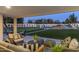 Inviting covered patio with comfortable seating overlooking a lush backyard with a pool and fun slide at 13365 N 74Th St, Scottsdale, AZ 85260