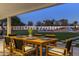Covered patio with a dining table, perfect for outdoor meals overlooking the luxurious backyard and pool at 13365 N 74Th St, Scottsdale, AZ 85260