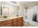 Bathroom includes dual sinks, framed mirror, tiled floor, and shower and tub combo at 14237 W Aster Dr, Surprise, AZ 85379