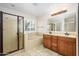 A bright bathroom features dual sinks, a separate shower, and a soaking tub with window at 14237 W Aster Dr, Surprise, AZ 85379