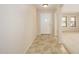 Bright foyer with tile flooring, white door and view into the carpeted living area at 14237 W Aster Dr, Surprise, AZ 85379