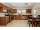 A kitchen boasts wooden cabinets, stainless steel appliances, tile flooring, and a window at 14237 W Aster Dr, Surprise, AZ 85379