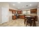 A kitchen features wooden cabinets, stainless steel appliances, tile flooring, and an adjacent dining area at 14237 W Aster Dr, Surprise, AZ 85379