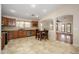An open kitchen with wood cabinets and tile floors flows seamlessly into the adjacent living area at 14237 W Aster Dr, Surprise, AZ 85379