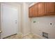 Laundry room with overhead cabinets and tile floor, plus room for washer and dryer at 14237 W Aster Dr, Surprise, AZ 85379