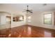 Open-concept living room with wood floors, ceiling fan, and view into the kitchen at 14237 W Aster Dr, Surprise, AZ 85379
